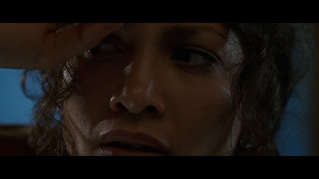 Close-up of a woman's face showing a worried expression, with curly hair partially covering her forehead.