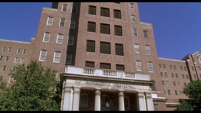 Exterior view of Hanridge Hospital, showcasing its brick facade and entrance columns against a clear blue sky.
