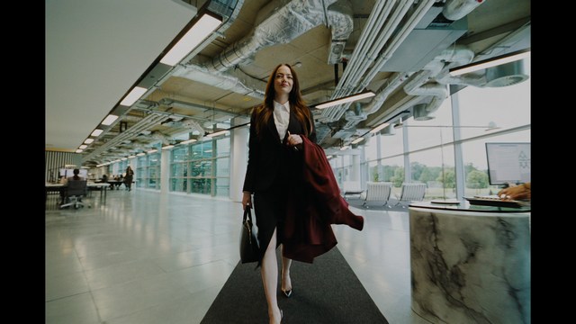 Three young individuals sitting together, two holding hockey sticks, with a casual and intense expression in a domestic setting.