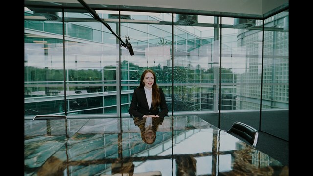 A close-up shot of a man with a distressed expression, featuring dark hair and wearing a blue hoodie, against a softly lit background.
