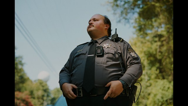 Three characters looking down with surprised expressions, framed from below.