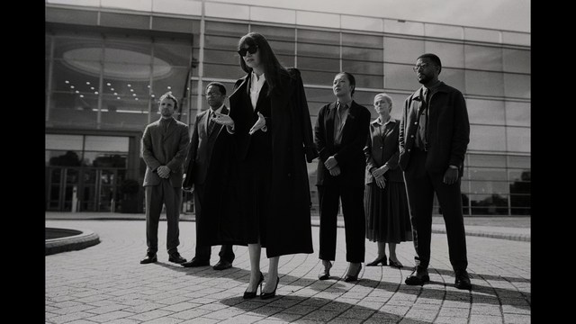 Two characters wearing red bandanas look surprised while standing in a dimly lit indoor setting.