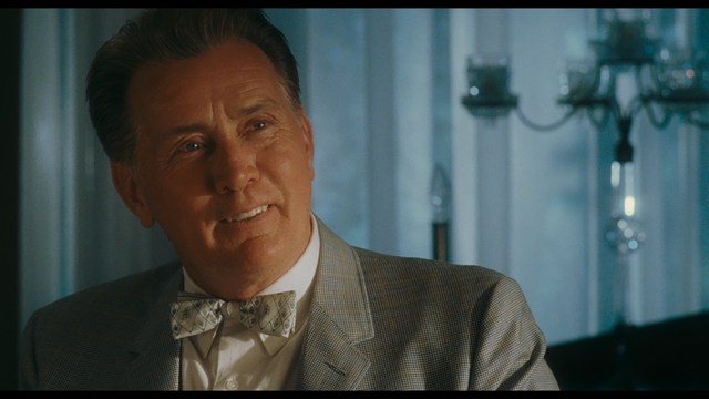 Two figures walking on a road towards a blue 'Welcome to New Jersey' sign.