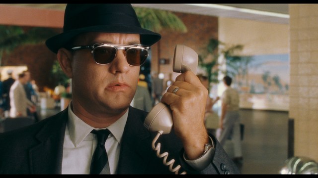 A sleek red futuristic car showcased in a high-tech environment, possibly a testing facility, with a modern design featuring large wheels and a distinctive silhouette.