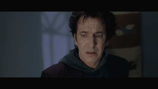 A still image from a film featuring a somber-looking man with dark hair, wearing a hoodie, expressing a concerned or troubled emotion.