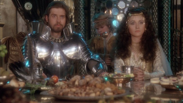 A group of armed personnel in futuristic uniforms looking intently at something off-screen, set against a dark, high-tech background.