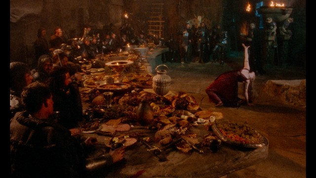 Four anthropomorphic turtles in ninja attire stand in a dimly lit room, while a humanoid character with fur sits nearby.