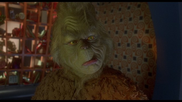 Scene from a church where a group of people, including a woman in a blazer and a young boy, are attending a service, facing forward with a stained glass window in the background.