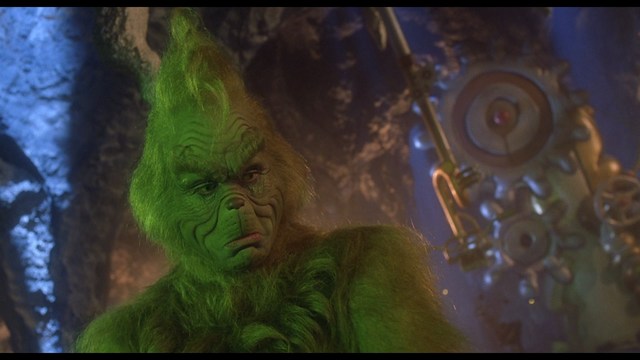 Scene featuring three characters on a roadside, discussing animatedly. A green landscape is visible in the background.