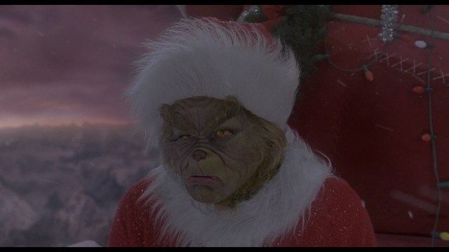 A woman sitting at a restaurant table, resting her chin on her hand while reading a newspaper.