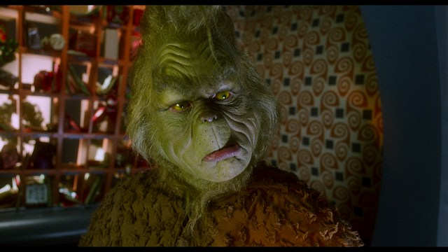 A group of people standing in a church, with a focus on a woman in a striped blazer looking up, while others are holding books or looking ahead.