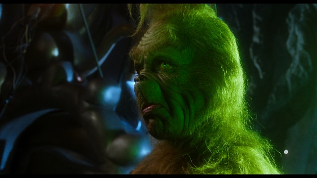 A young man pointing a handgun while seated in a bus, showcasing an intense expression.