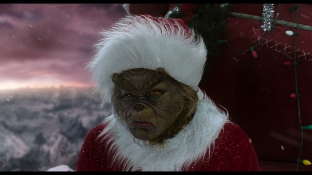 A woman seated at a restaurant table, thoughtfully resting her chin on her hand while reading a newspaper. Blurred figures of two people can be seen in the background.