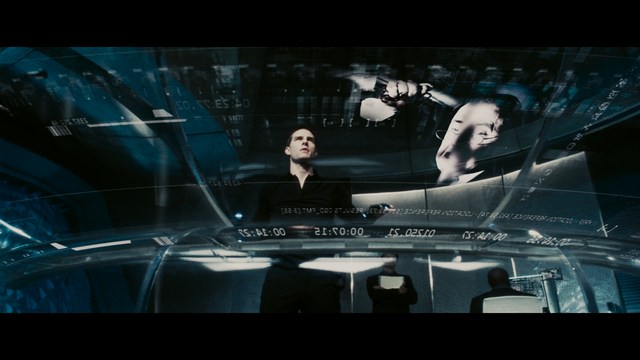 A scene from a movie featuring two young men sitting closely together in an airport waiting area, with one holding a box of popcorn.