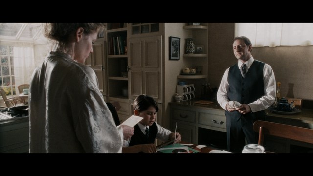 A group of people standing in a church, with a focus on a woman in a striped blazer looking up, while others are holding books or looking ahead.