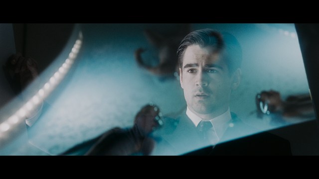 Three young individuals sitting together, two holding hockey sticks, with a casual and intense expression in a domestic setting.