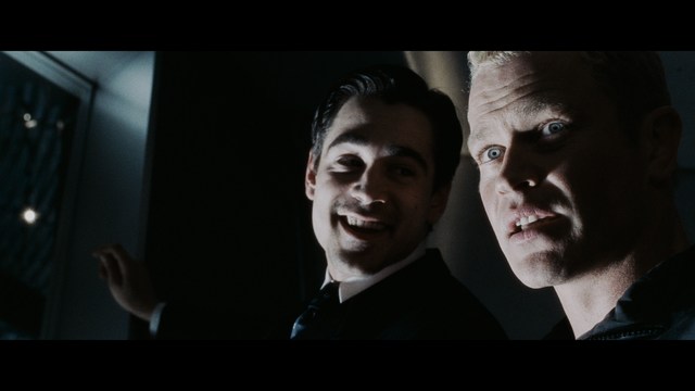 A close-up shot of a man with a distressed expression, featuring dark hair and wearing a blue hoodie, against a softly lit background.