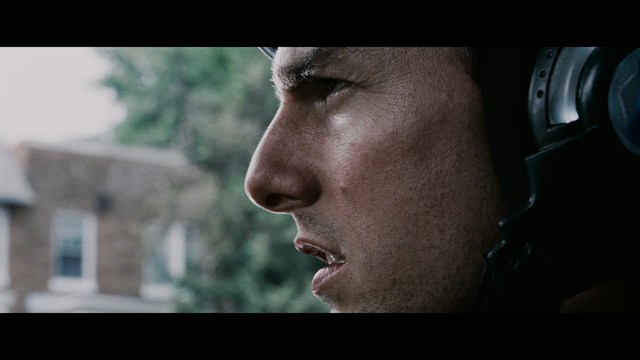 A young man pointing a handgun while seated in a bus, showcasing an intense expression.