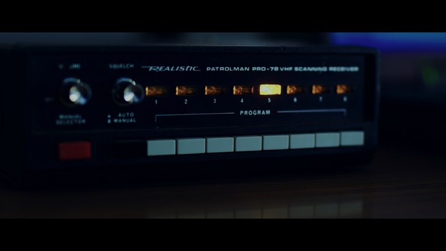 Four anthropomorphic turtles in ninja attire stand in a dimly lit room, while a humanoid character with fur sits nearby.