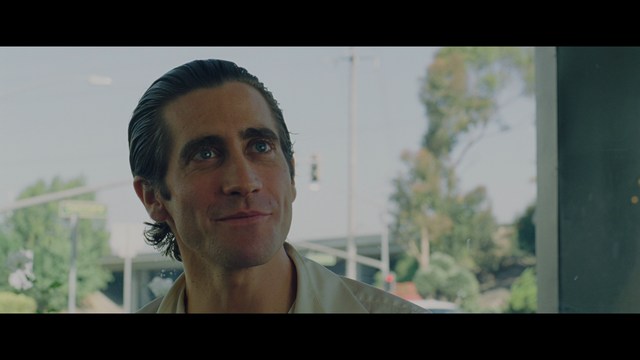 Three young individuals sitting together, two holding hockey sticks, with a casual and intense expression in a domestic setting.