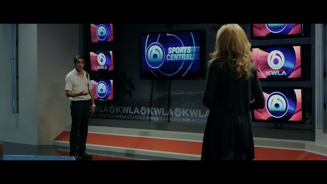 A worried woman stands on a deserted road, looking shocked or distressed as she gazes into the distance.