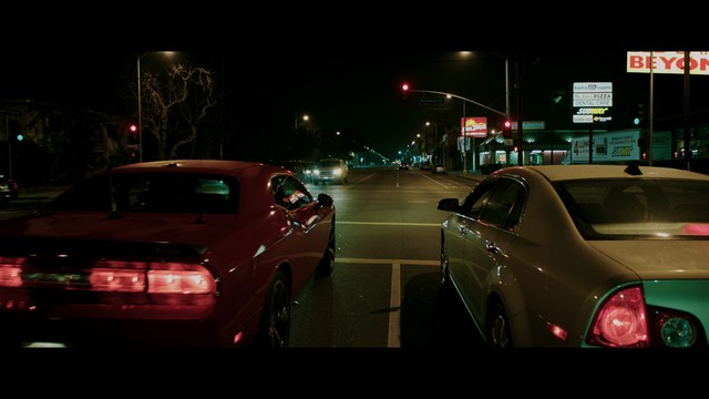 Two characters wearing red bandanas look surprised while standing in a dimly lit indoor setting.