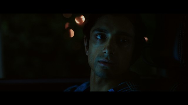 A sleek red futuristic car showcased in a high-tech environment, possibly a testing facility, with a modern design featuring large wheels and a distinctive silhouette.