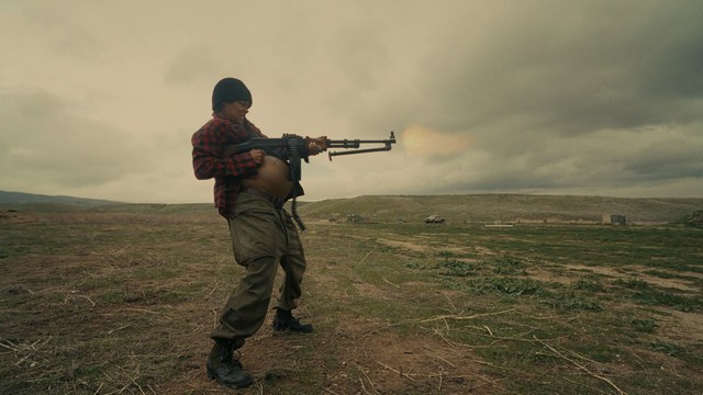 Four anthropomorphic turtles in ninja attire stand in a dimly lit room, while a humanoid character with fur sits nearby.