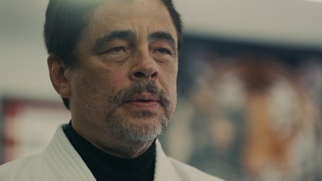 Three young individuals sitting together, two holding hockey sticks, with a casual and intense expression in a domestic setting.