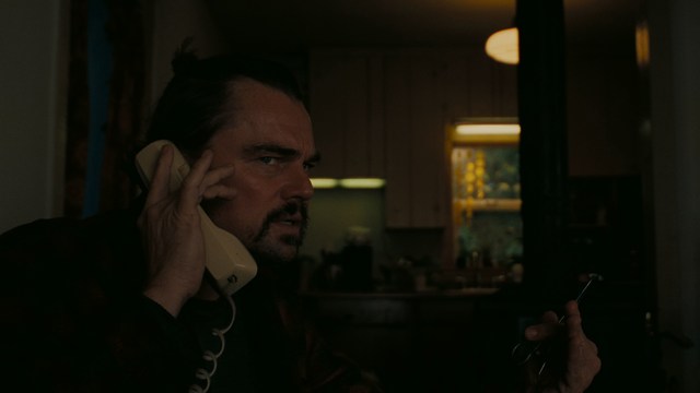 A worried woman stands on a deserted road, looking shocked or distressed as she gazes into the distance.