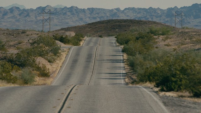 A group of characters in futuristic gear, looking tense and alert, possibly in a sci-fi setting.