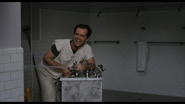 A young man pointing a handgun while seated in a bus, showcasing an intense expression.