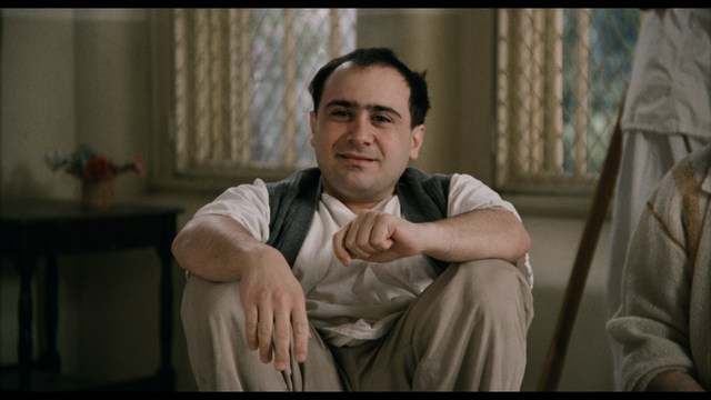 Two characters wearing red bandanas look surprised while standing in a dimly lit indoor setting.