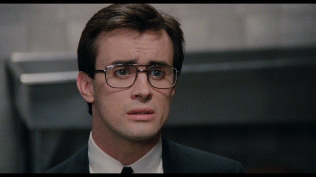 Four anthropomorphic turtles in ninja attire stand in a dimly lit room, while a humanoid character with fur sits nearby.