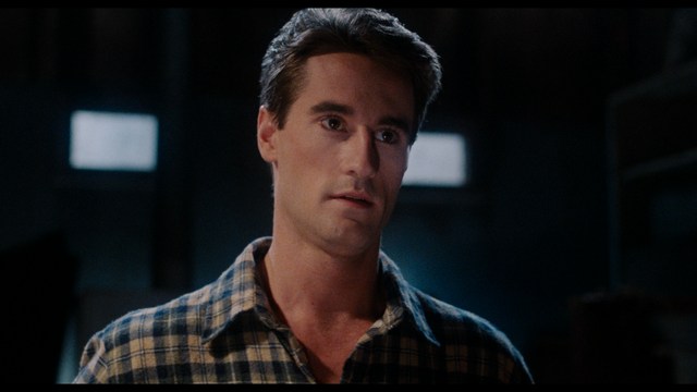 Three young individuals sitting together, two holding hockey sticks, with a casual and intense expression in a domestic setting.