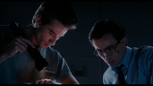 A scene featuring five characters in a bar setting, with a focus on their expressions and interactions. The backdrop includes bar shelves with bottles and a bartender visible in the background.