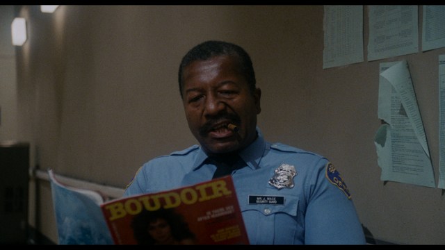 Two figures walking on a road towards a blue 'Welcome to New Jersey' sign.