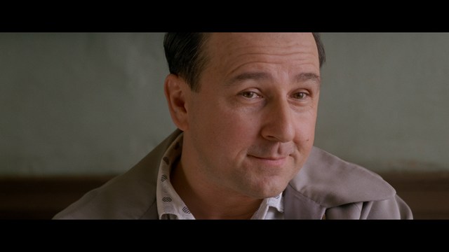 A close-up of a person's hand holding a crumpled newspaper with the headline "Mooby's: Creating an Empire Out of Simplicity" and a graphical chart showcasing growth, titled "It was a very Good YEAR."