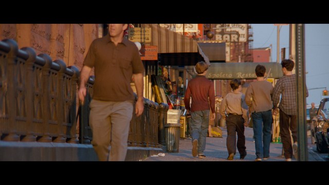 A young man pointing a handgun while seated in a bus, showcasing an intense expression.