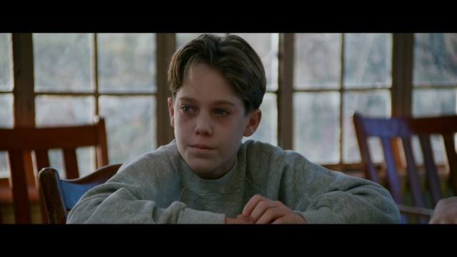 Two figures walking on a road towards a blue 'Welcome to New Jersey' sign.
