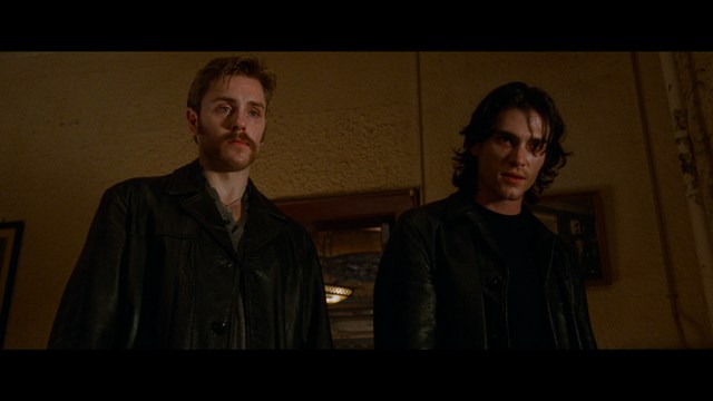 A group of characters in futuristic gear, looking tense and alert, possibly in a sci-fi setting.