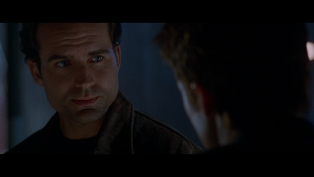 A sleek red futuristic car showcased in a high-tech environment, possibly a testing facility, with a modern design featuring large wheels and a distinctive silhouette.