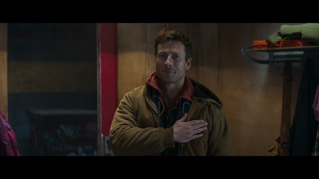 A close-up of a person's hand holding a crumpled newspaper with the headline "Mooby's: Creating an Empire Out of Simplicity" and a graphical chart showcasing growth, titled "It was a very Good YEAR."