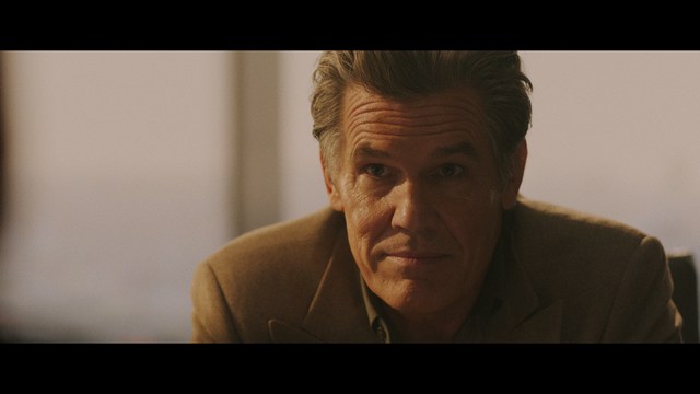 Two characters sitting in a diner, one wearing a blue beanie with 'SNOOGANS' and the other wearing a cap, both looking intently at something off-screen.