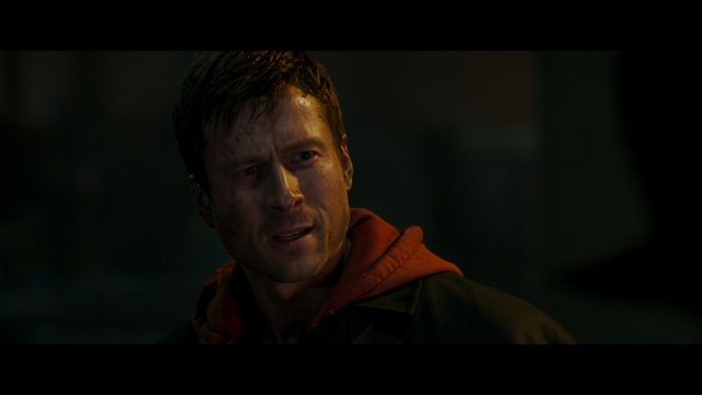 A sleek red futuristic car showcased in a high-tech environment, possibly a testing facility, with a modern design featuring large wheels and a distinctive silhouette.