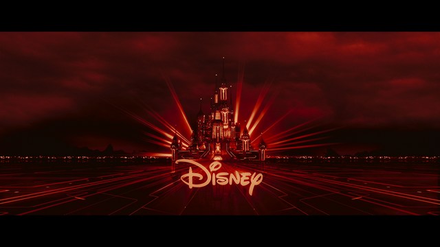 A still from a movie featuring a man standing on a boardwalk in front of an arcade with signs for Skeeball, saltwater taffy, and various attractions.