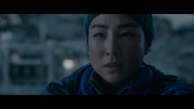 A scene featuring five characters in a bar setting, with a focus on their expressions and interactions. The backdrop includes bar shelves with bottles and a bartender visible in the background.