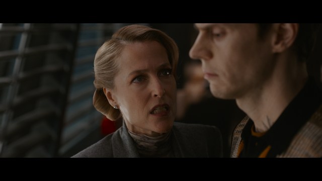 Two figures walking on a road towards a blue 'Welcome to New Jersey' sign.