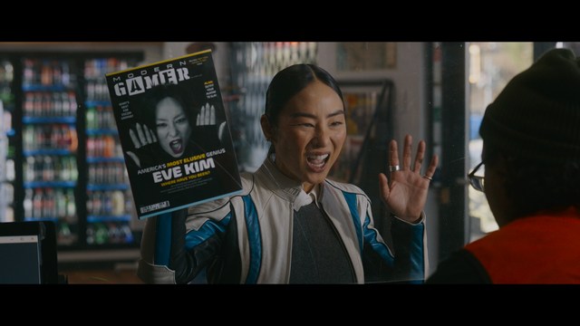 Aerial view of futuristic skyscrapers with cars driving vertically up the side of a building, showcasing a modern urban landscape.