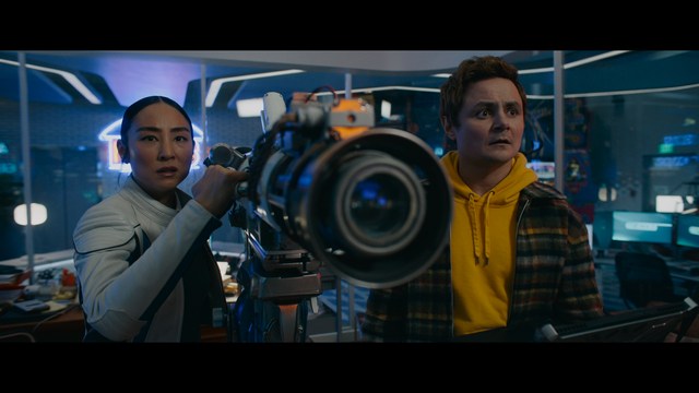 A sleek red futuristic car showcased in a high-tech environment, possibly a testing facility, with a modern design featuring large wheels and a distinctive silhouette.